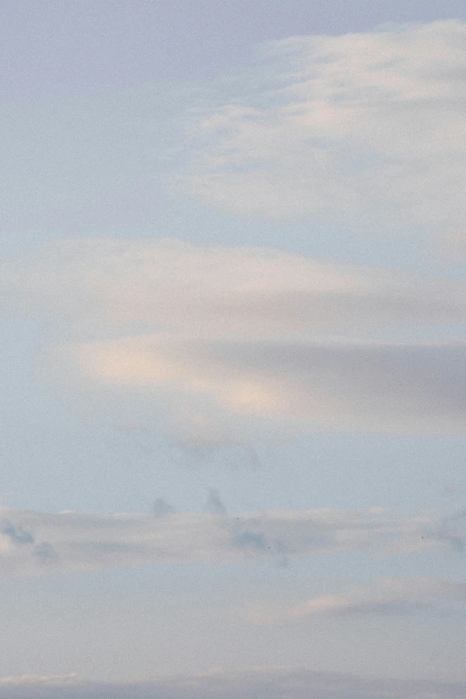 a plane flying over on top of a cloudy sky