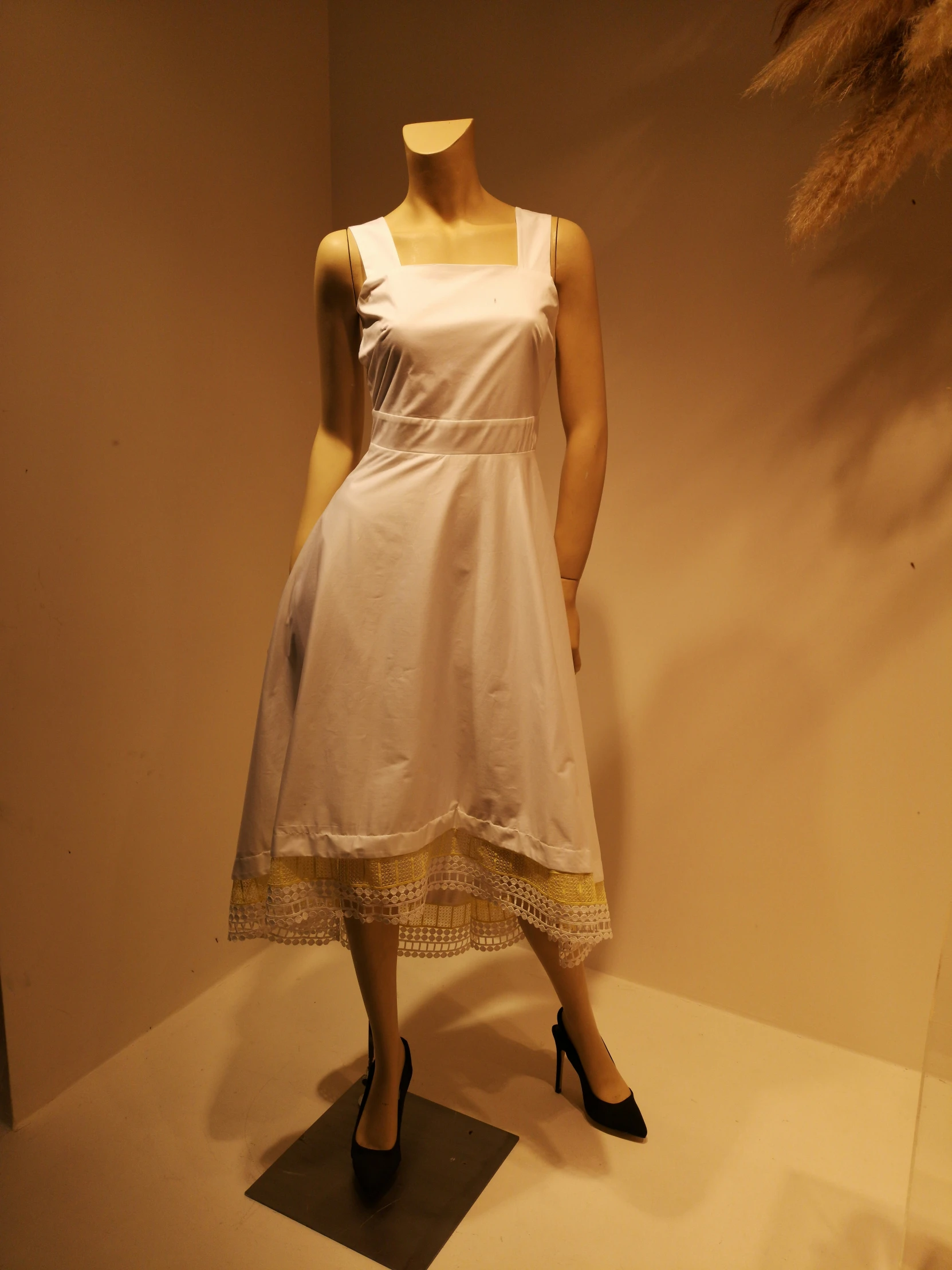 dress with golden trim sitting on mannequin in window display