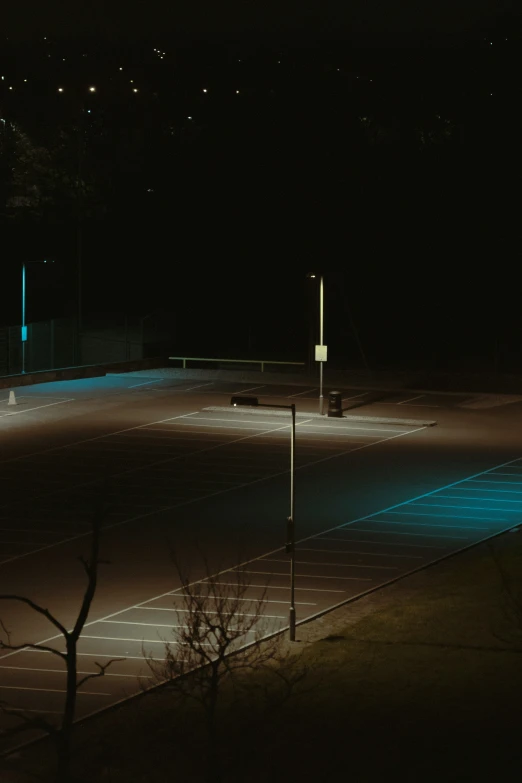 an empty tennis court with neon lights all around it