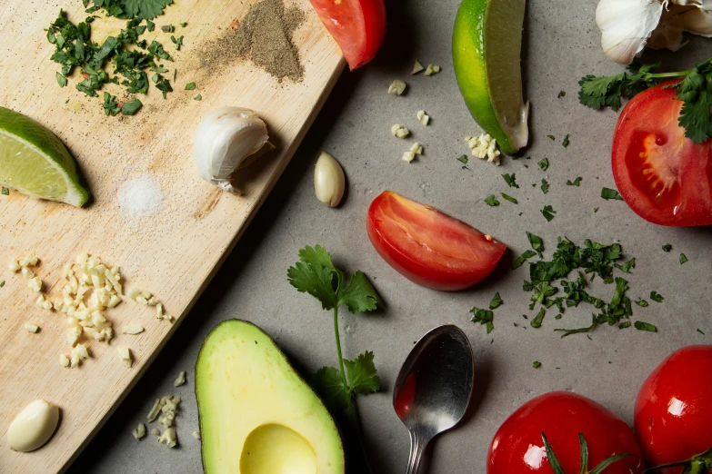 several vegetables are on a  board with spoons