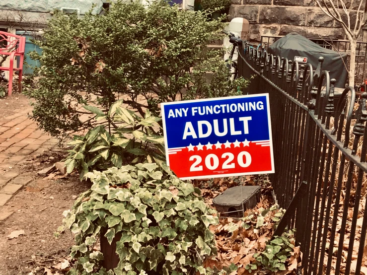 a blue and red sign next to a fence