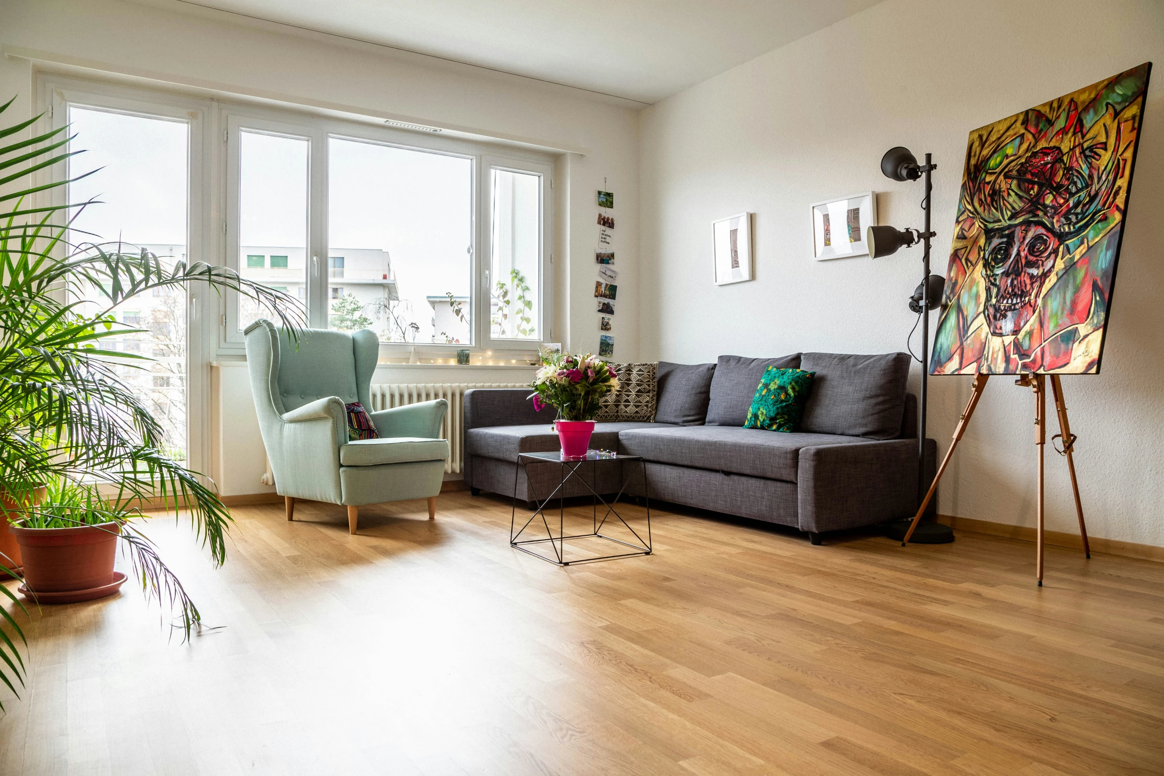 a living room with wooden floors and paintings