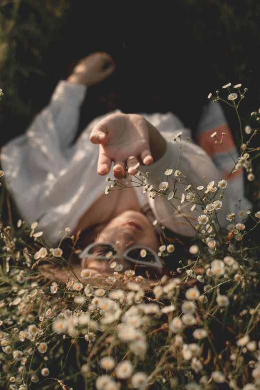 a person laying down on a field with flowers