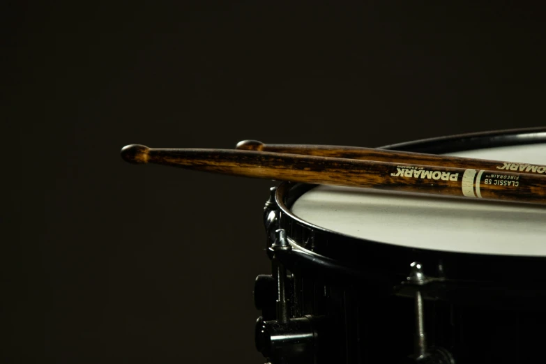 two drum sticks sitting on top of a white drum