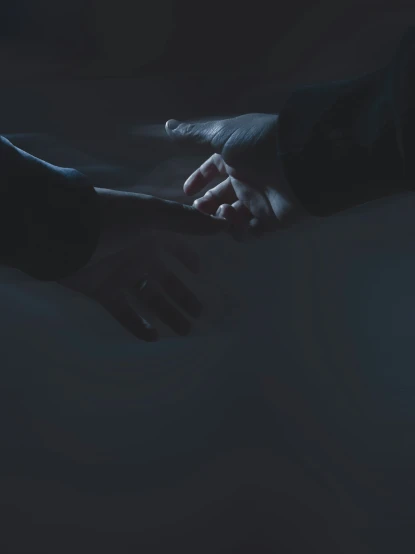 two hands reaching to each other in the dark