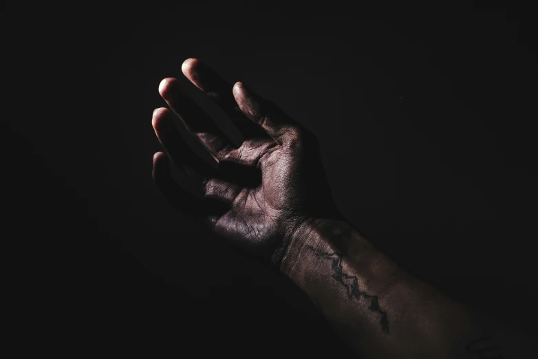 a black hand with a cross drawn on it