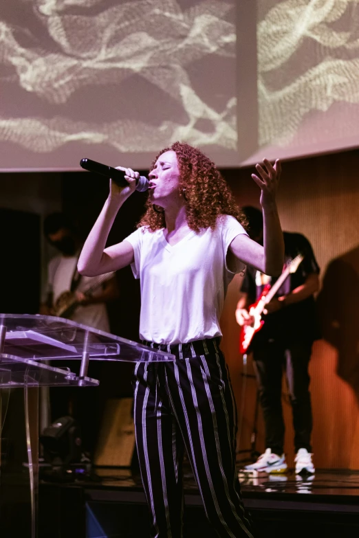 a woman holding a microphone and singing into a microphone