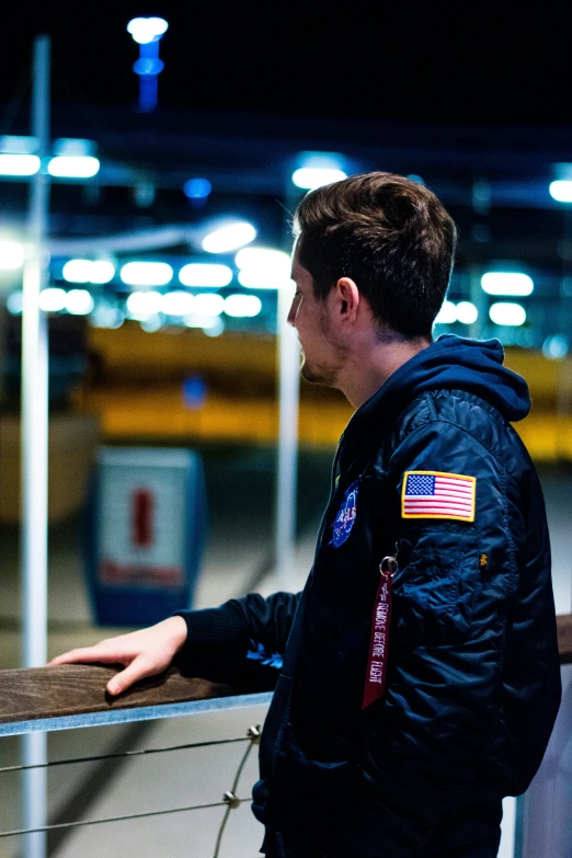 young man standing at an airport looking out the window