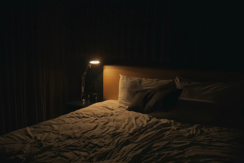 a dimly lit bed in the dark of night