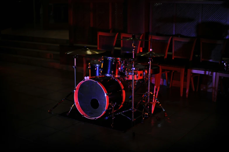 drum kit illuminated up with bright lights in an empty room
