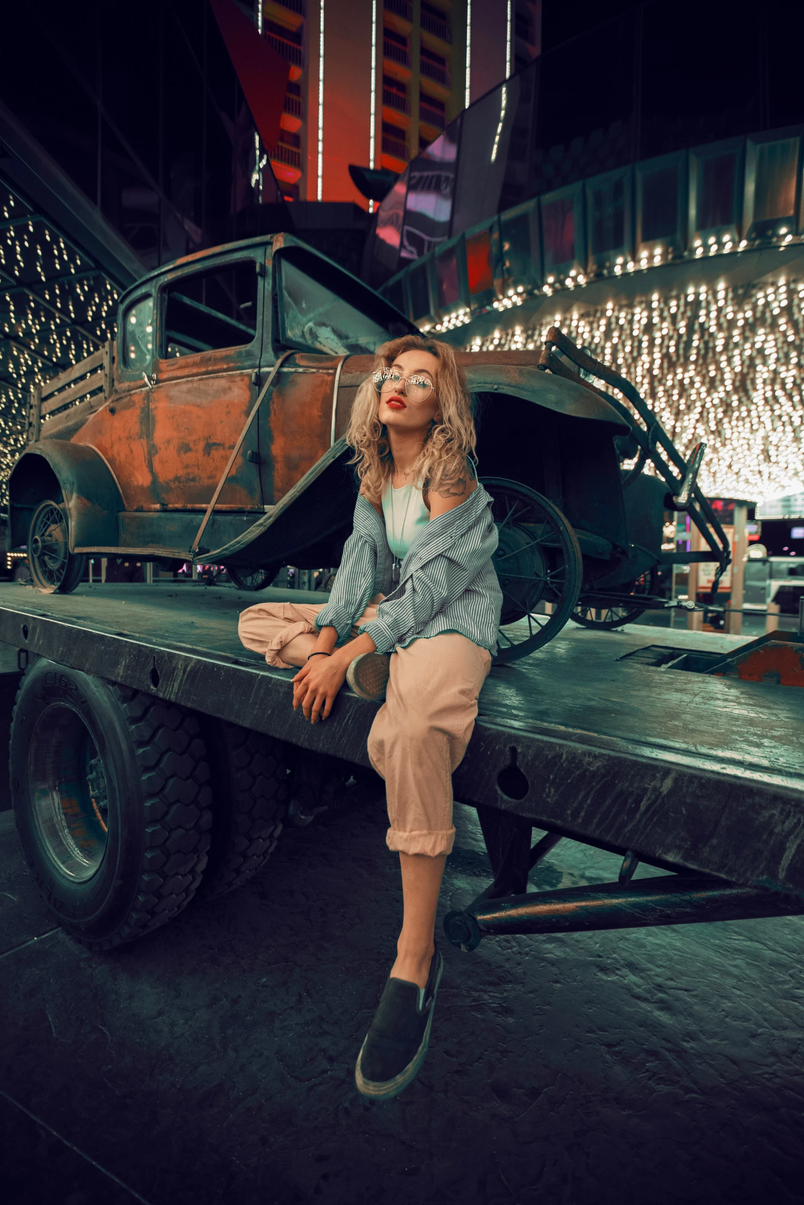 a beautiful blond woman sitting on top of a truck