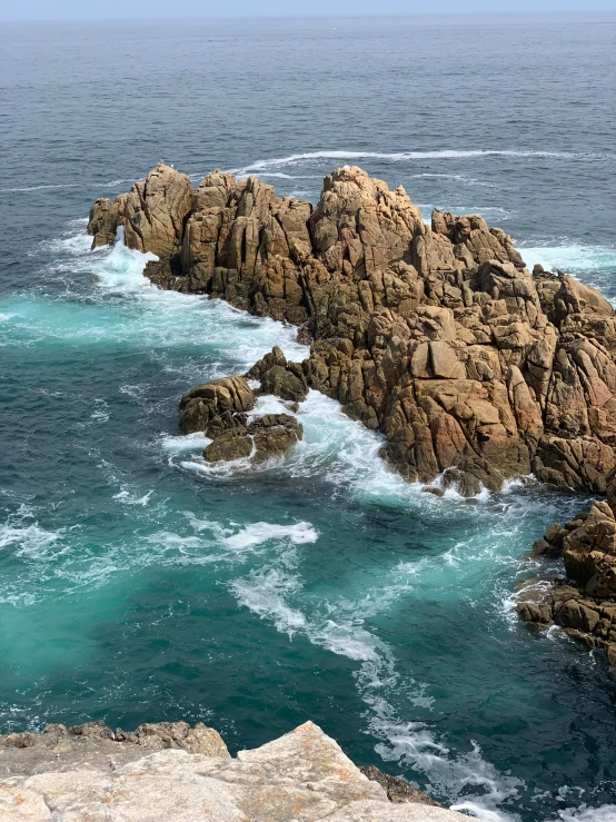 the rocky coast in the ocean is covered in blue water