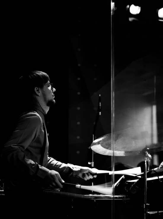 a man is playing drums in black and white