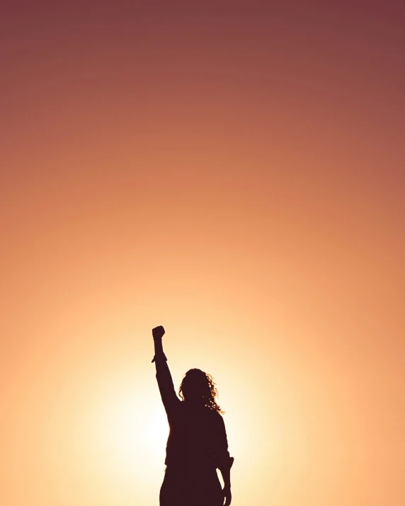 a person standing in the sunlight while holding a kite