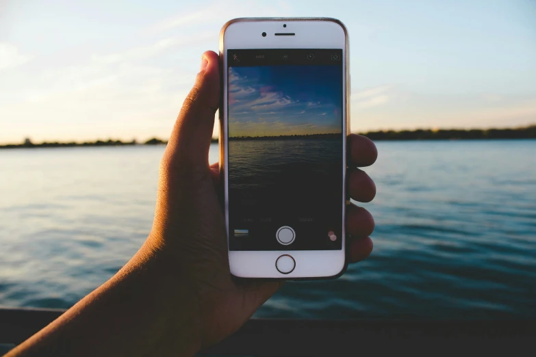 a hand holding an iphone up to show the landscape