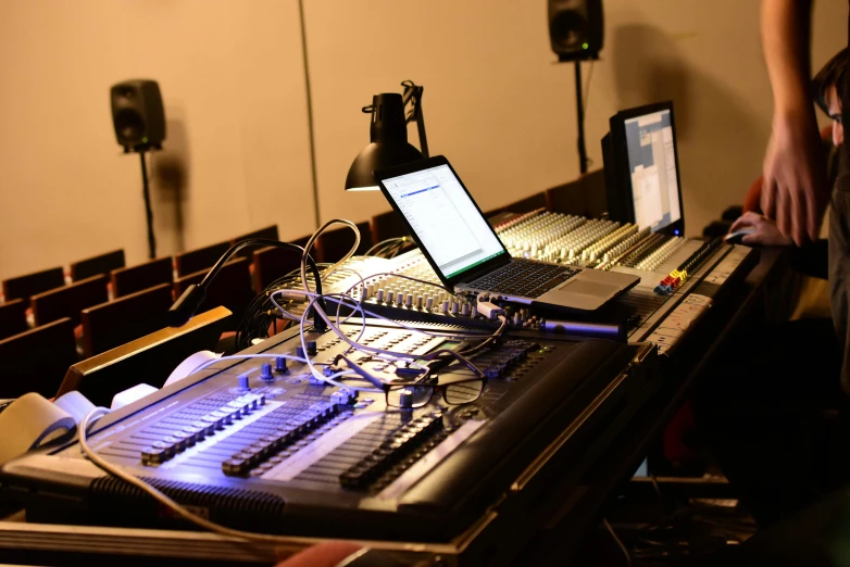 a computer screen on top of a large sound mixing table