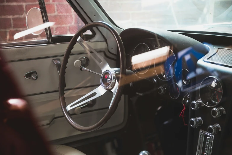 interior of a classic car with black trim and wood steering wheel