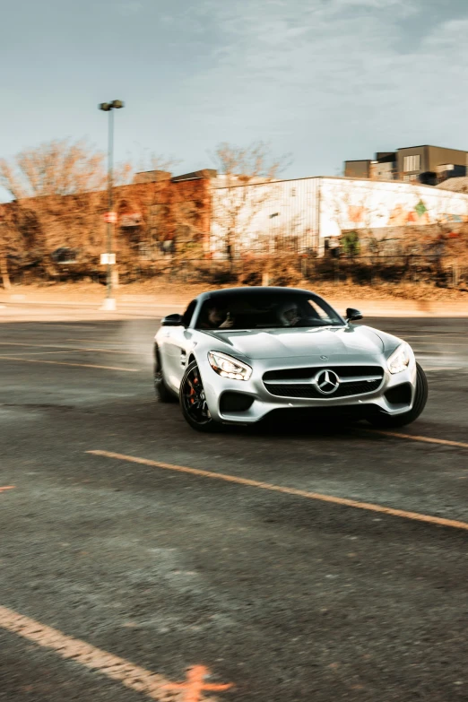 the front view of a white mercedes car driving in an empty lot