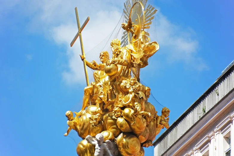 a gold statue with a cross on top of it