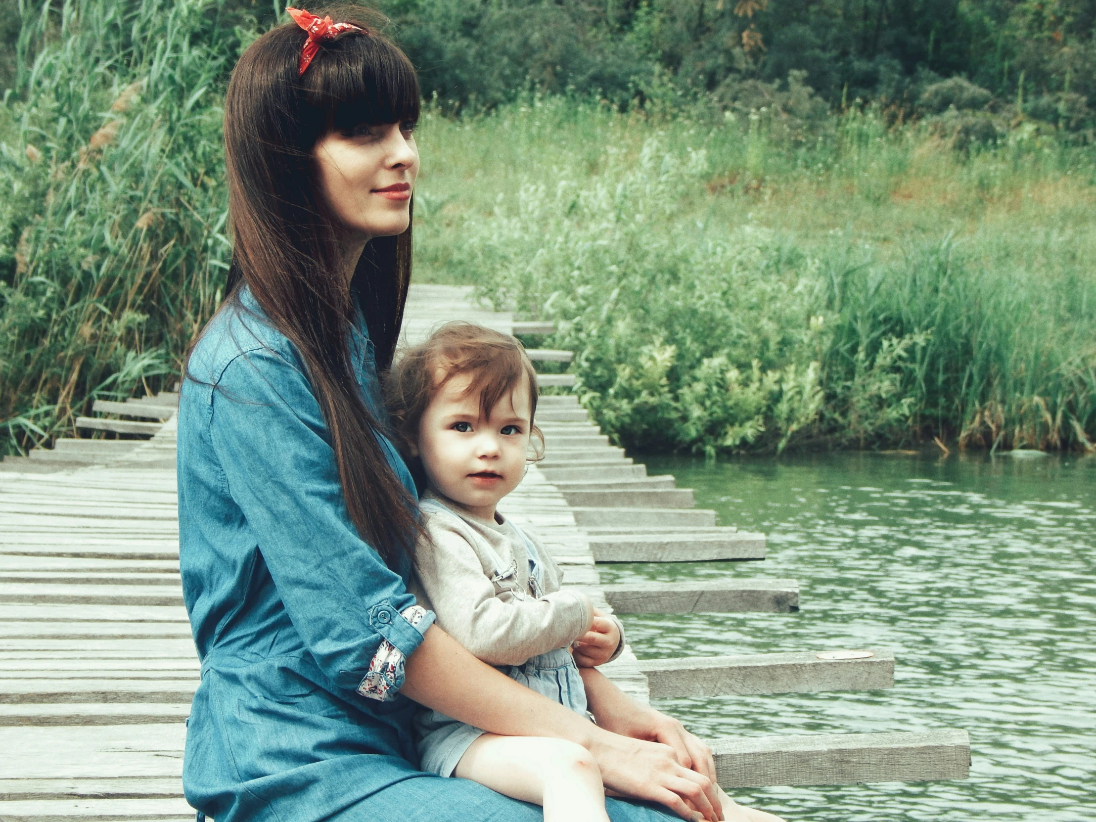 a woman sitting next to a small girl