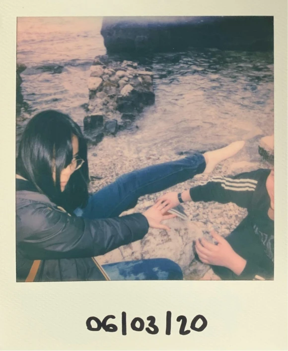 there is a polaroid picture of a woman laying on the sand