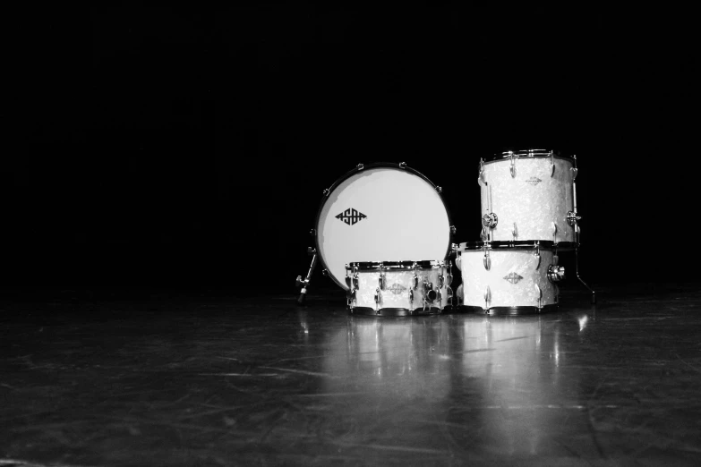 black and white po of three drums on a shiny surface