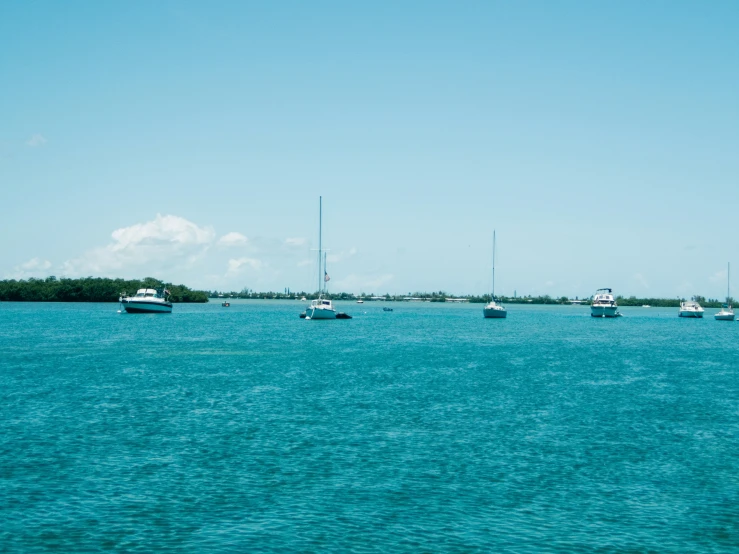 sailboats are sitting on a bright blue body of water