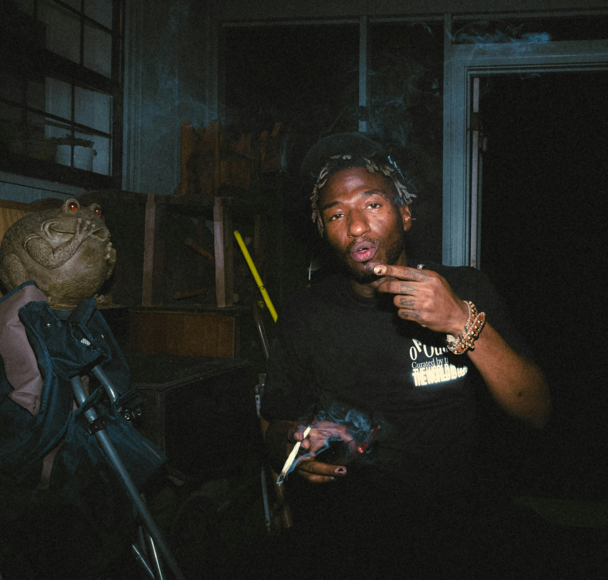 a man smoking a cigarette next to a backpack