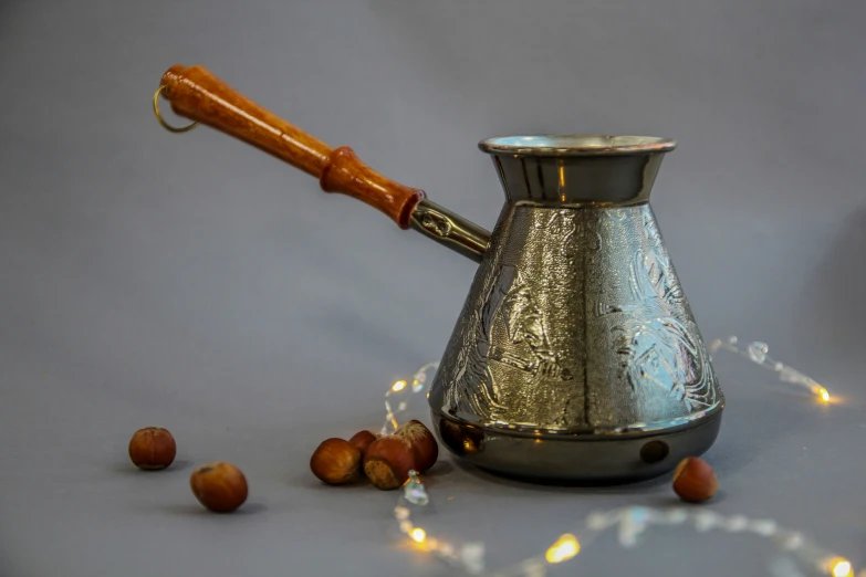 silver jug with orange handle, surrounded by little lights