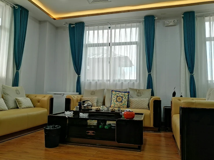 a room with three different colored couches, and a black coffee table in the center