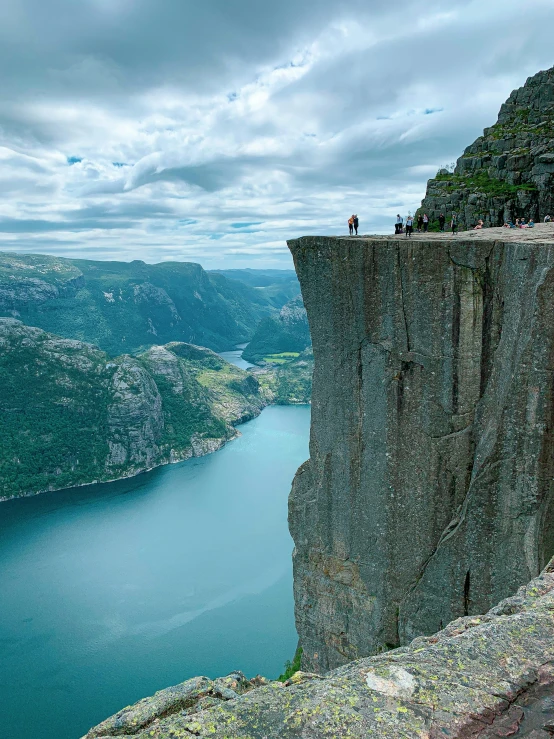 people are standing at the top of a cliff