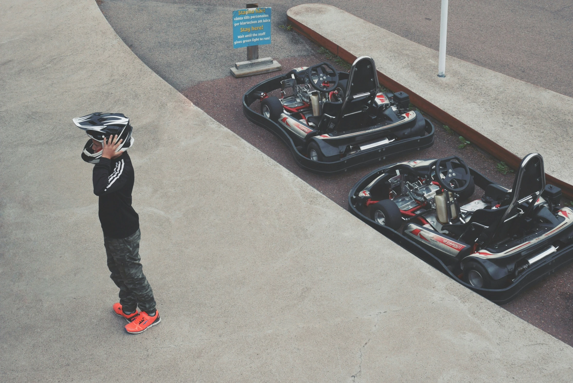 a small child on a skateboard looking at cars
