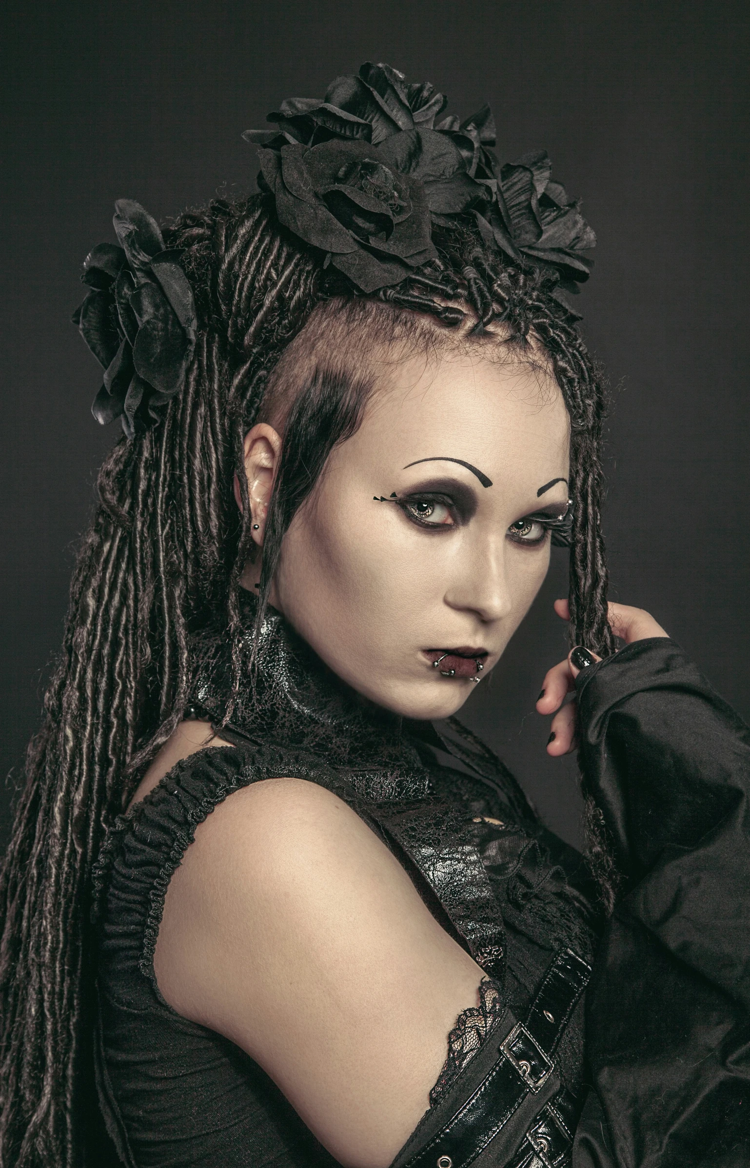 a woman with dark makeup, dreadlocks and black clothing