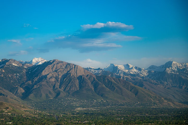 a hill with snowy capped mountains below it