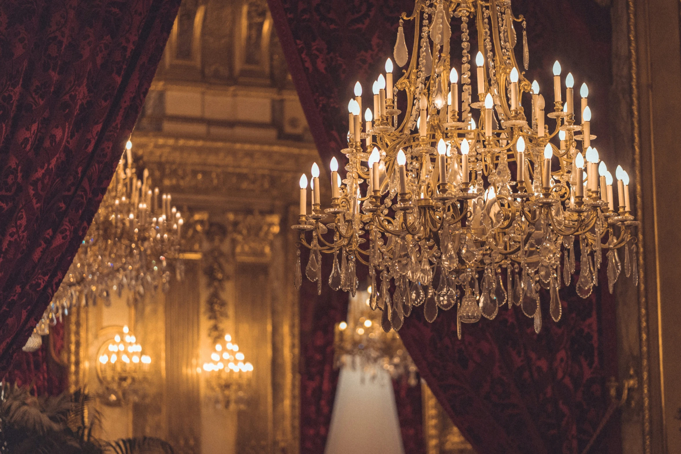 an elaborate chandelier hangs from the ceiling with gold leaf designs