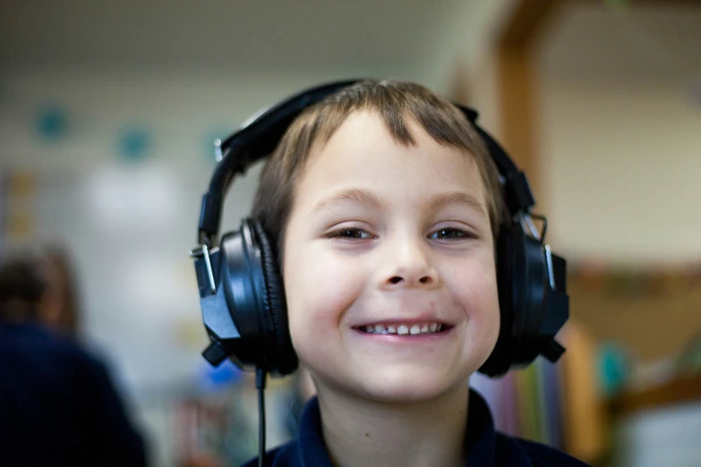 a  with headphones smiling and looking at the camera