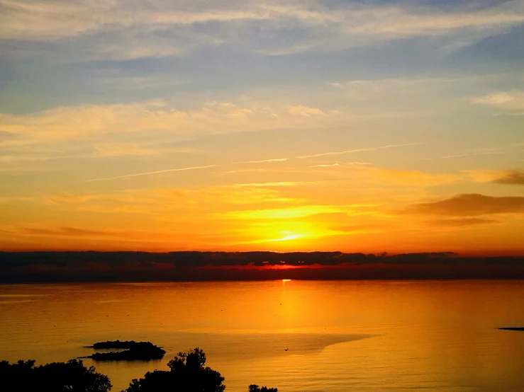 an image of sunset with the sky reflected in water