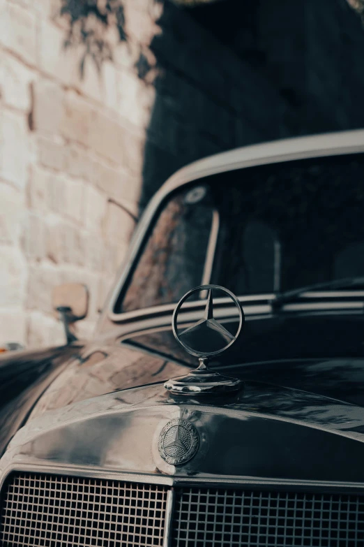 a black mercedes parked by some stone wall