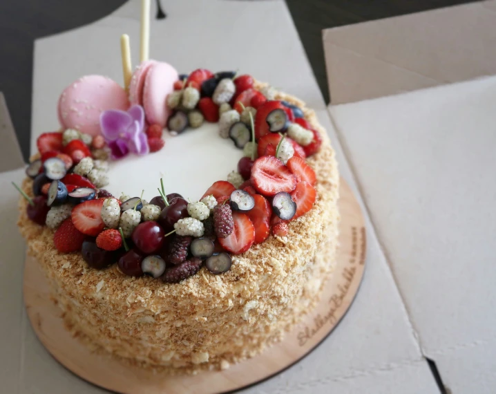 an iced cake covered with strawberries, strawberries and other toppings