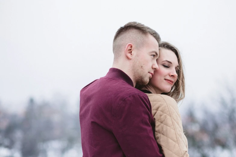 a young couple emce on a snowy day