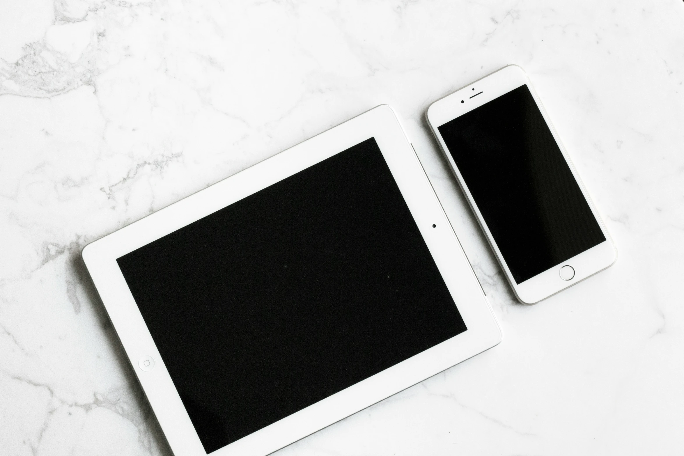 two tablets with black screens on a white background