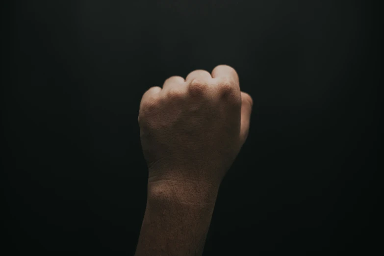 a hand holds up a black phone screen in the dark