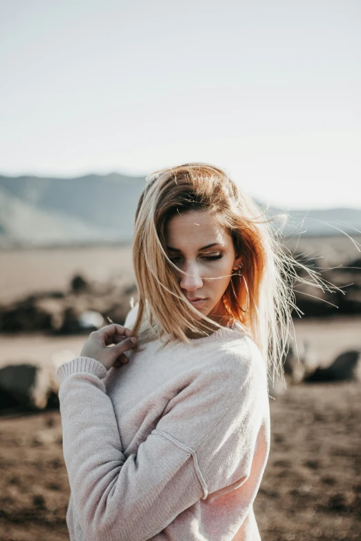 a beautiful blonde girl standing outdoors in the desert