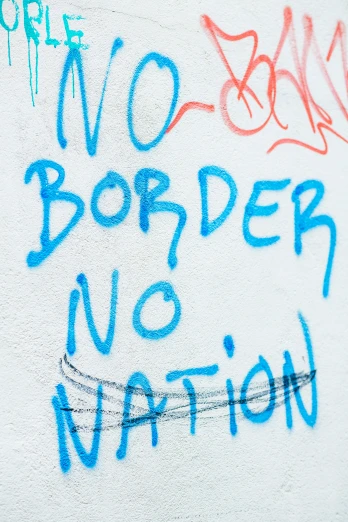 graffiti on a wall stating no borders, no nations