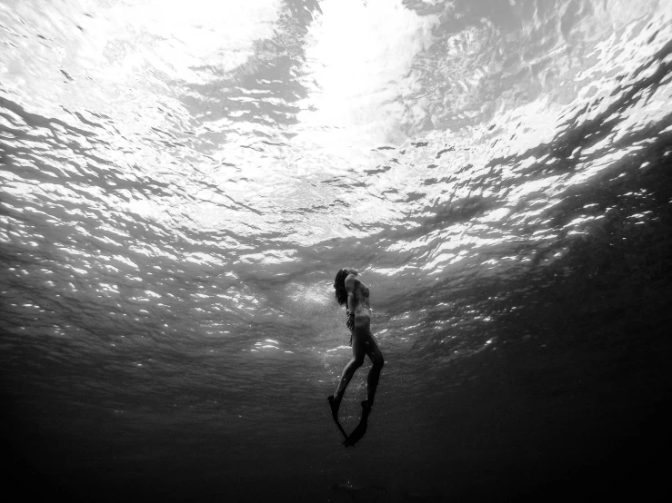 a person under water in the ocean with surfboard