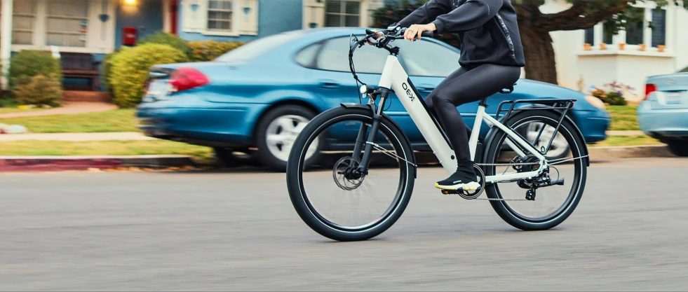 a person in black riding a bike down a street