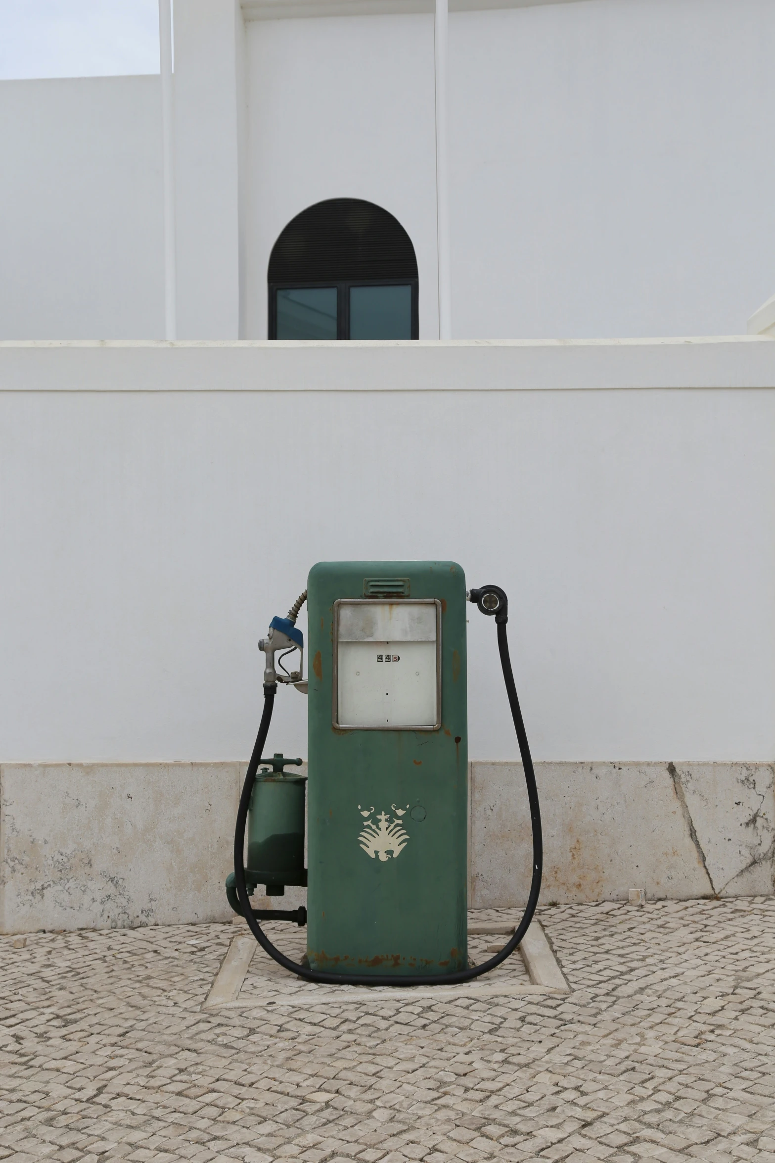 an old gas pump with no top on the street