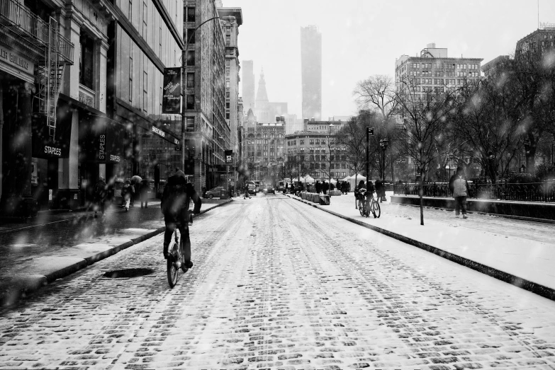 a couple of people walking down a road on a rainy day