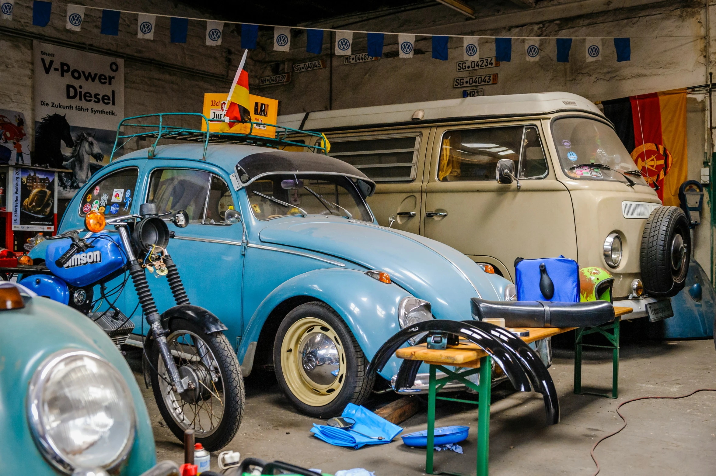 a vintage vw beetle is parked inside a garage with a blue bike