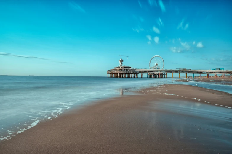 the sandy beach is next to a pier